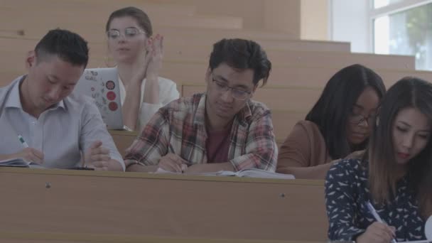 Studera skriva ner information elever sitter i Akademins klassrummet. — Stockvideo