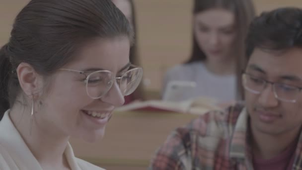 Sorrindo, rindo menina sentada na universidade . — Vídeo de Stock