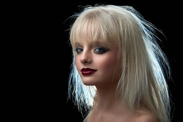 Model with blonde dishevelled hair looking at camera.