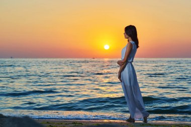 Güzel kız tek başına on sunset kumsalda yürüyüş.