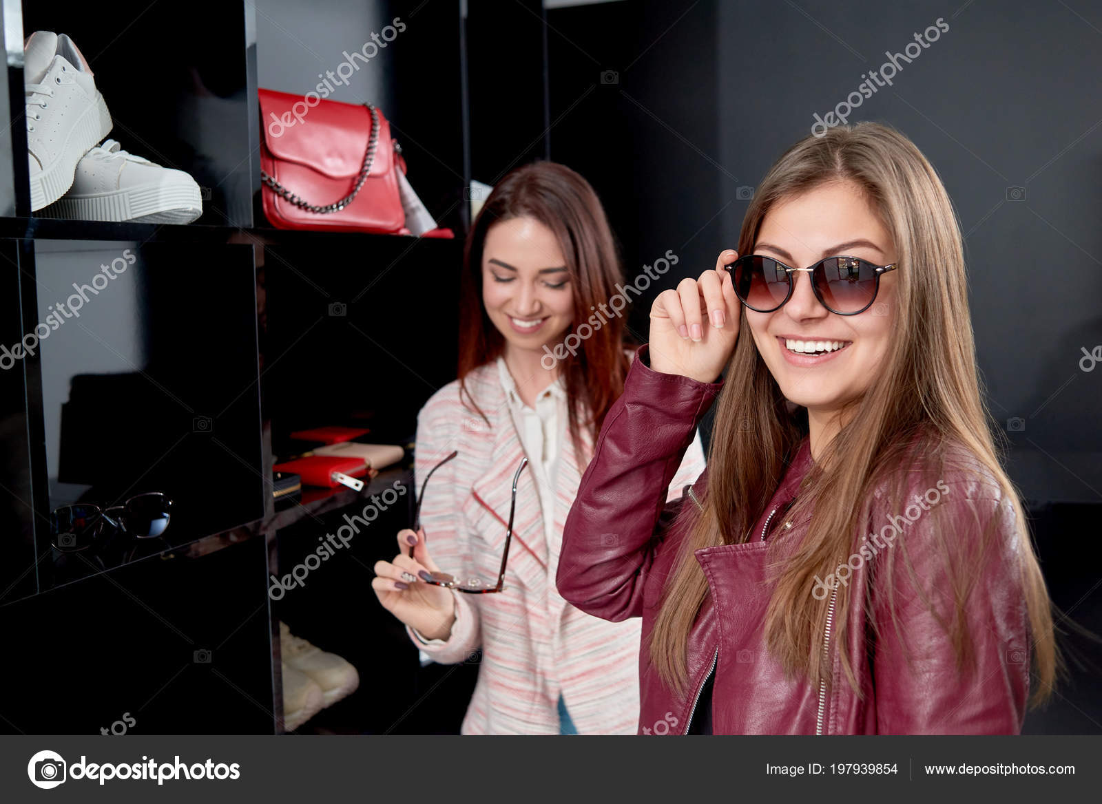 Duas lindas garotas da moda em óculos e roupas modernas posando com óculos  para a imagem da câmera de meninas elegantes em óculos