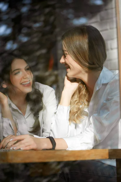 Duas amigas a rir perto do vidro da janela . — Fotografia de Stock