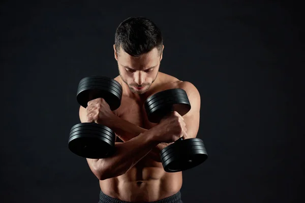 Portrait of man keeping dumbbells with crossed hands. — Stock Photo, Image