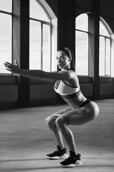 Fekete-fehér fénykép, vonzó nő, sportos testtel felült csinál. — Stock Fotó