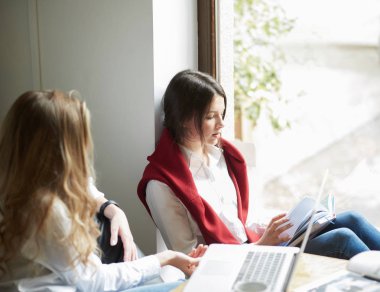 Eğitim projesi için birlikte çalışan iki kız öğrenci.