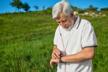 Yaşlı adam açık havada spor aktiviteleri sırasında zaman kontrol.