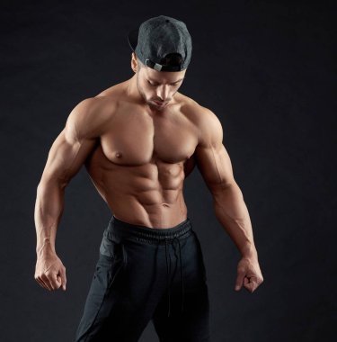 Bir şapkası vücut geliştirmeci poz portresi.