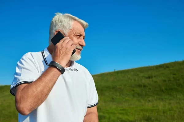 Sideview olahragawan berbicara di ponsel saat hari cerah . — Stok Foto