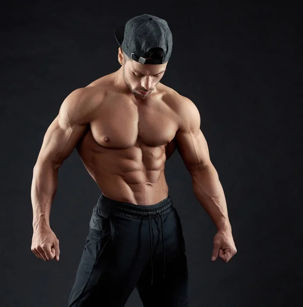 Portrait of posing bodybuilder wearing a cap. — Stock Photo, Image