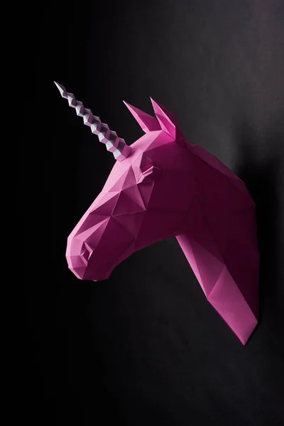 Насичена рожева голівка єдинорогів висить на чорній стіні . — стокове фото