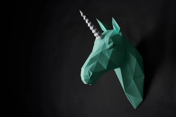 Origami grön enhörningar huvud hängande på svart vägg. — Stockfoto