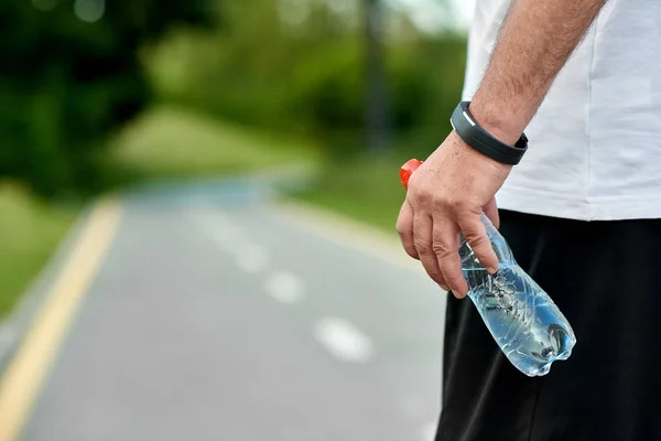 Olahraga tangan menjaga air botol runningon racetrack . — Stok Foto