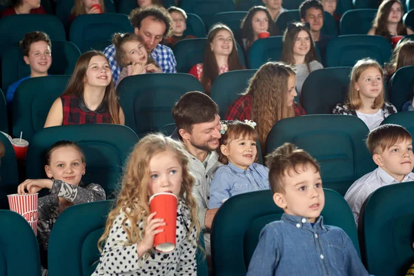 Rodzice i dzieci oglądanie filmu w kinie i zabawne. — Zdjęcie stockowe