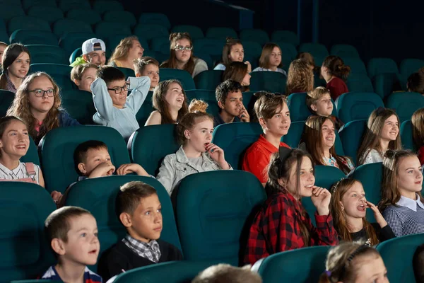 Cheerful children smiling and watching cartoon in movie theatre — Stock Photo, Image