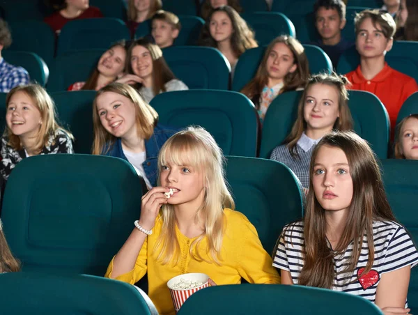 10 代の若者を見て面白い映画と映画館に笑みを浮かべて. — ストック写真