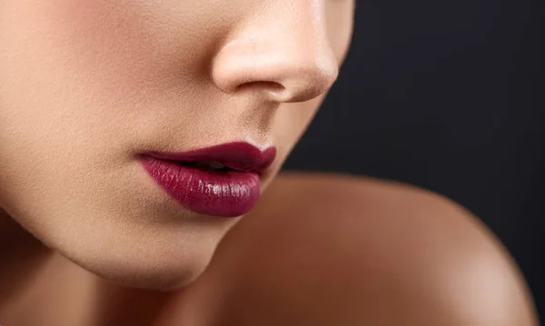 Recortado cerca de los labios de las mujeres cubiertos con lápiz labial oscuro . —  Fotos de Stock