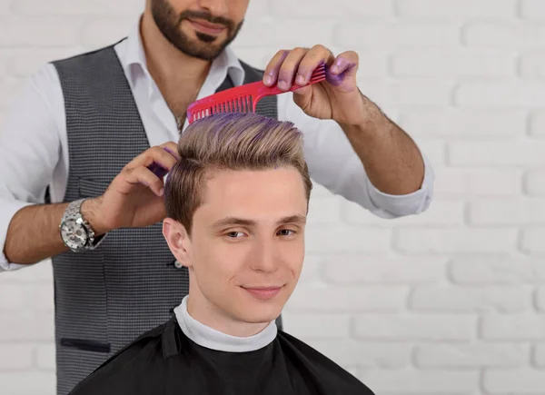 Oříznuté sideview kadeřník dělá vlasy fialové barevné tónování pro mladé chlapce. — Stock fotografie