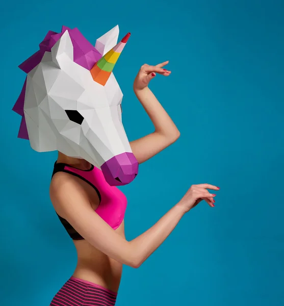Chica joven posando con máscara de unicornios sobre fondo azul saturado . —  Fotos de Stock