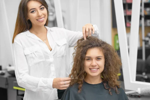 Χαμογελαστά Γυναικεία Hairstylist Εργάζονται Νέους Σγουρά Πελάτη Βλέπουν Φωτογραφικών Μηχανών — Φωτογραφία Αρχείου