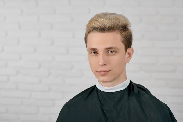 Jovem modelo masculino com cabelo loiro à espera de novo penteado . — Fotografia de Stock