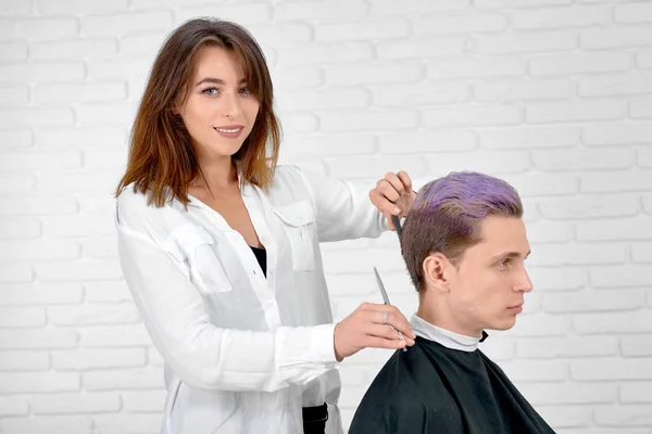 Ženské kadeřník dělá účes pro mladé klienta s ochablé vlasy. — Stock fotografie