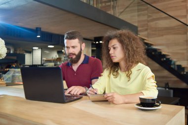 Kafede oturan eğitim projesi için çalışan iki genç öğrenciler.