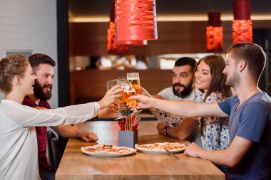 Pizzacı bira bardakları tokuşturup arkadaş grubu.