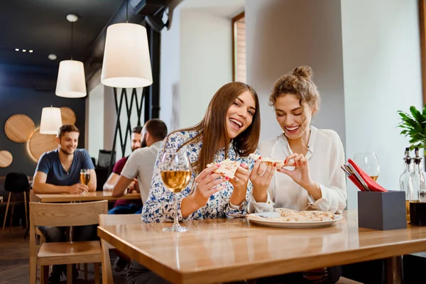 Splendide giovani donne che mangiano pizza nel ristorante . — Foto Stock