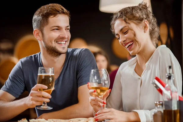 Schönes Paar mit Gläsern Weißwein und Bier im Restaurant. — Stockfoto