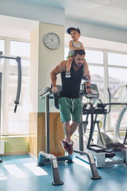 Küçük oğlu üzerinde boyun tutulması simülatör eğitim sporcu önden görünümü.