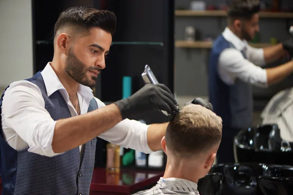Концентрированный парикмахерская обрезка клиента с помощью триммера . — стоковое фото