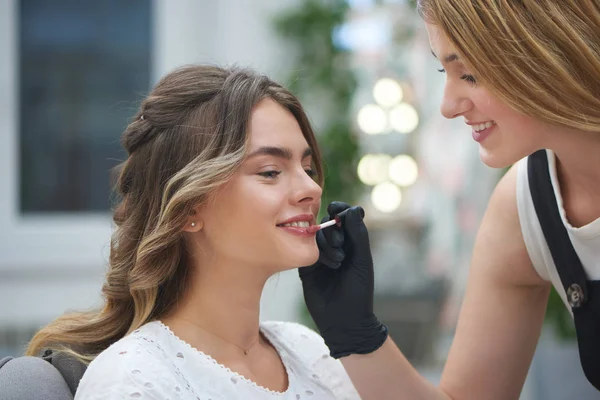 Maquillaje artista aplicando brillo labial en salón de belleza —  Fotos de Stock