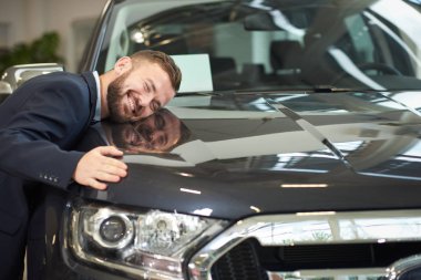 Araba kaputa yalan ve otomatik sarılma gülümseyen adam.