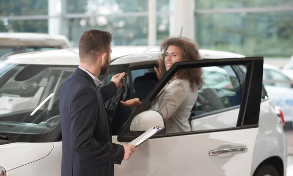 Wanita bahagia mengambil kunci oh mobil baru dari manajer . — Stok Foto