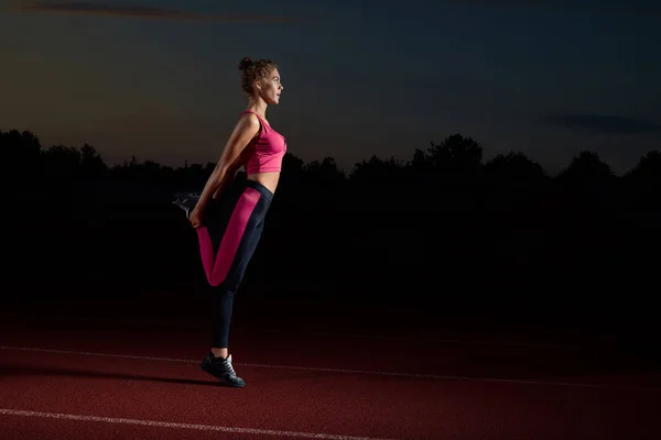 Sportowy kobieta robi, rozciągający się na nogach po biegu. — Zdjęcie stockowe