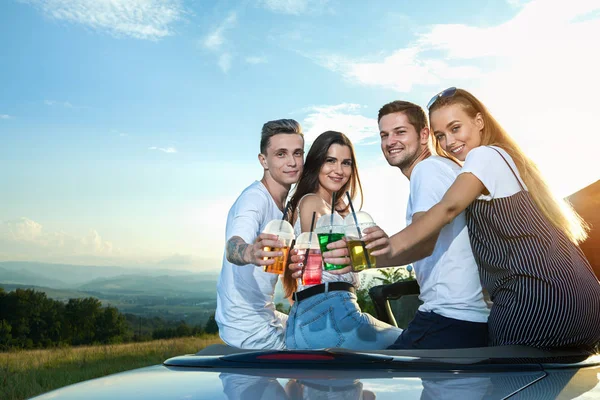 Stiliga män och flickor sitter på cabriolet, spottar lemonad glasögon. — Stockfoto