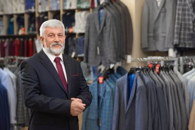 Bu erkek butik ayakta gri saçlı sahibi.