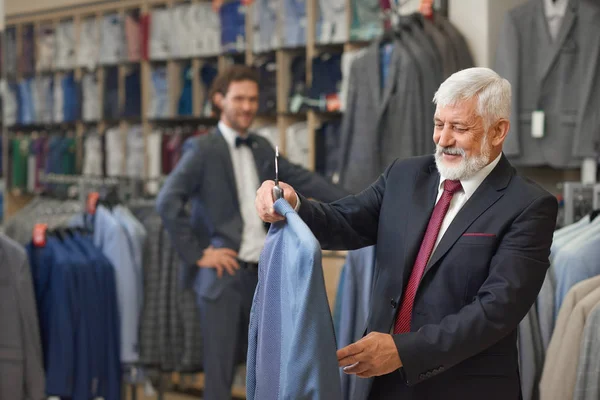 Bonito sênior com cabelos grisalhos escolhendo roupas elegantes . — Fotografia de Stock