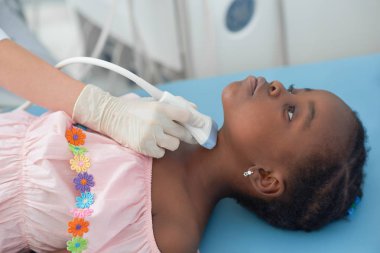 Afro kız yatakta tiroid ultrason sırasında yalan.
