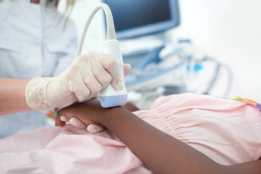 Doktor hastanın el özel cihazla incelenmesi.