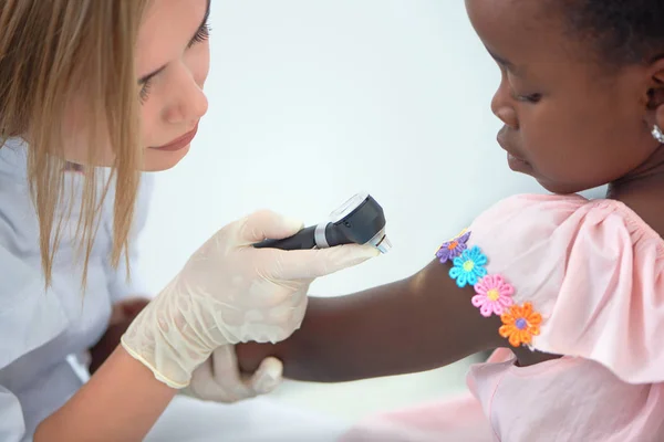लहान आफ्रिकन मुलीच्या खांद्यावर त्वचा तपासणी सुंदर डॉक्टर . — स्टॉक फोटो, इमेज