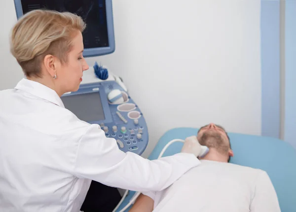 Arzt macht Ultraschalluntersuchung des Nackens des Patienten. — Stockfoto