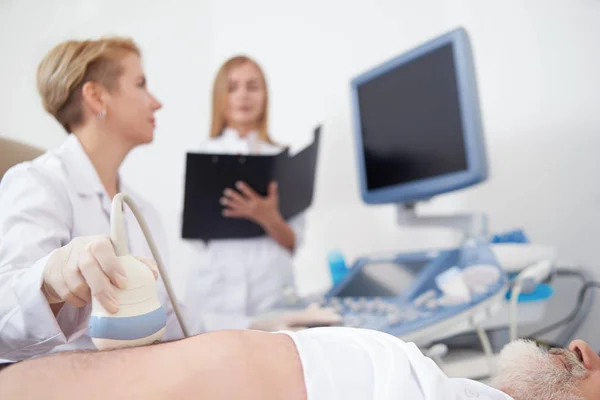 Médico examinando con ultrasonido diagnósticos vientre mans . — Foto de Stock