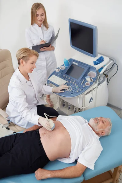 Anciano en diagnóstico de ultrasonido en consultorio médico . —  Fotos de Stock