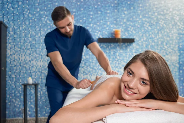 Mujer sonriente mirando a la cámara durante el masaje criollo en el spa — Foto de Stock