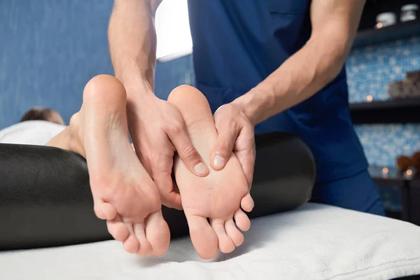 Primo piano di mani di massaggiatore che massaggia il piede di femmina in spa — Foto Stock