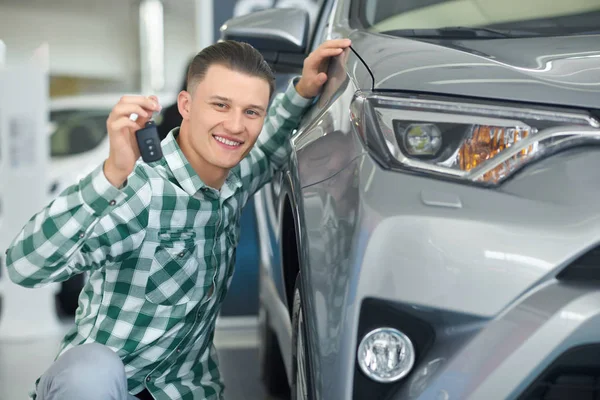 Feliz conductor sonriente comprar vehículo gris y mostrar la clave . —  Fotos de Stock