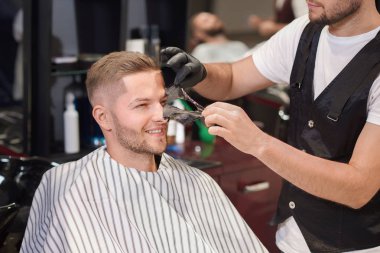 Berber Kuaför dükkanında adamın yüzü siyah maske kaldırma