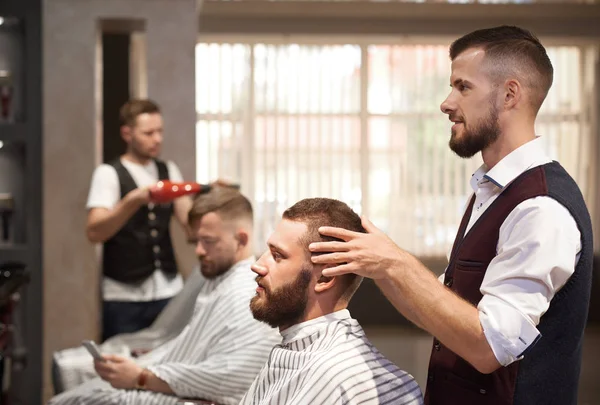 Barbier regarder miroir sur les cheveux du client avant la coupe de cheveux — Photo