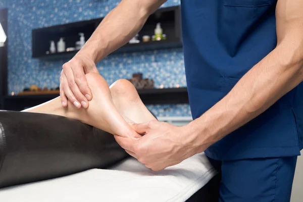 Closeup of relaxing massage of female foot in spa salon